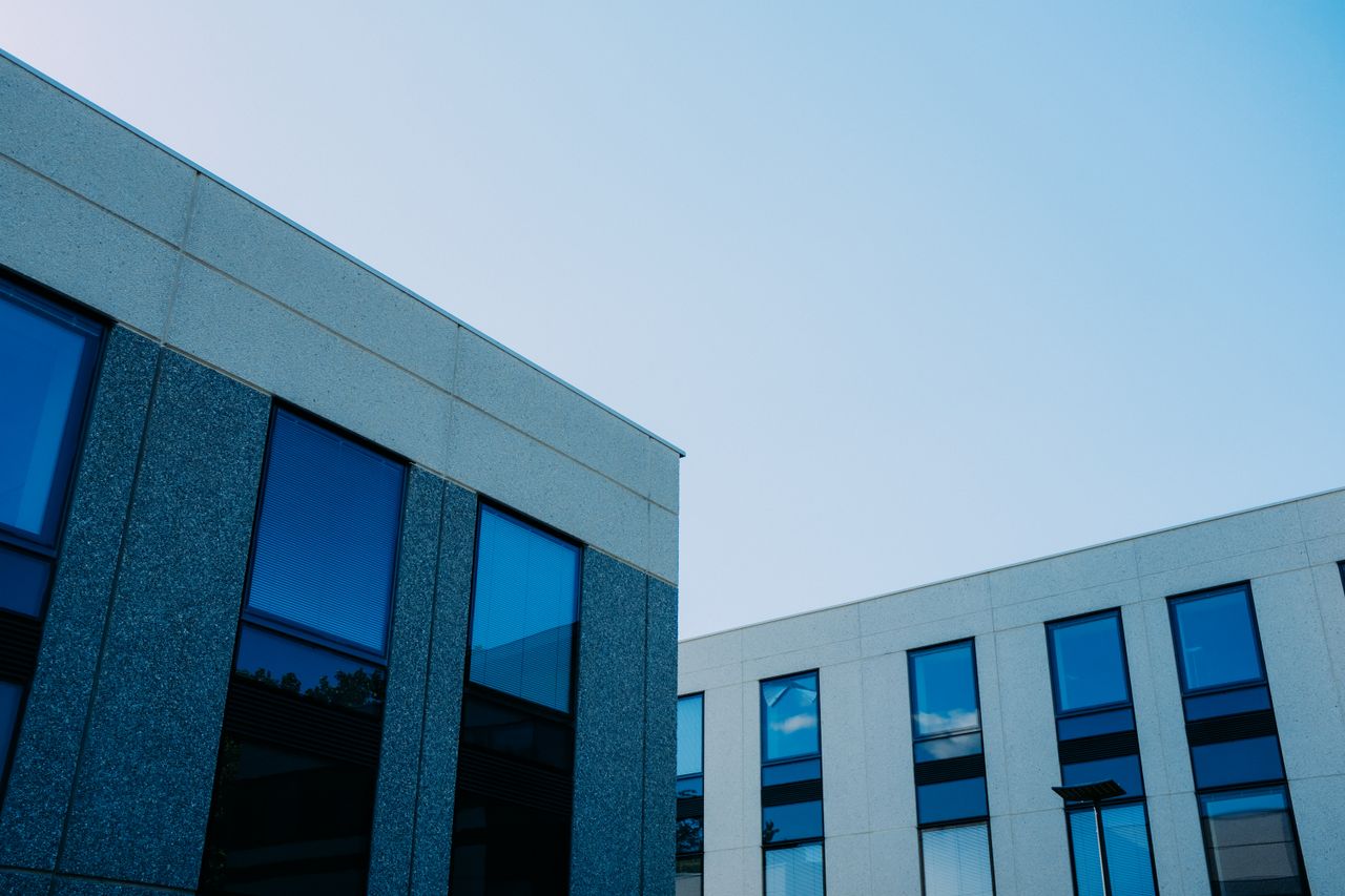 Services From below of contemporary office buildings with reflection in windows located in city
